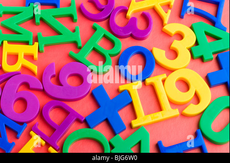 Objekt auf rot - Spielzeug aus Kunststoff-Buchstaben und Zahlen Stockfoto