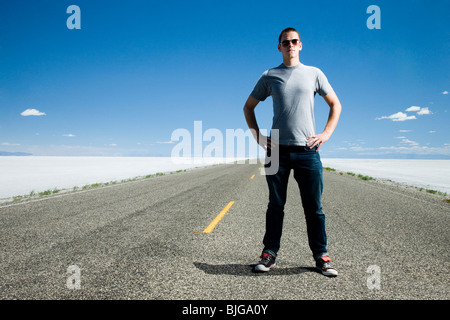 Mann auf einer Straße mitten im nirgendwo Stockfoto