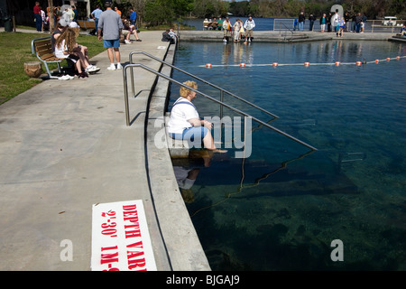 Frau sitzt mit Füßen im Wasser bei De Leon Springs Florida Stockfoto