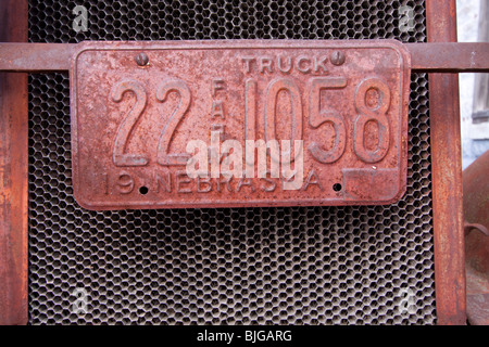 Eine verrostete Bauernhof-Kfz-Kennzeichen auf einem Rost, Oldtimer in Nebraska, USA. Stockfoto