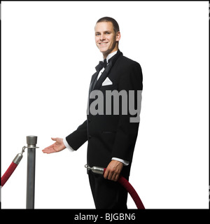 Mann in einem Smoking neben einer Samtkordel Stockfoto