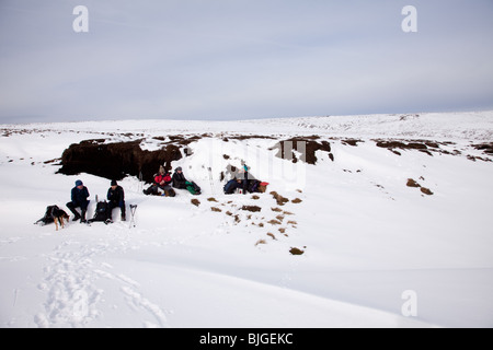 Winterwandern auf Bleaklow in Derbyshire Peak District - eine Mittagspause Stockfoto