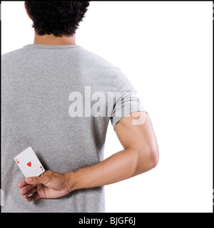 Mann, der eine Ass-Karte hinter seinem Rücken hält Stockfoto