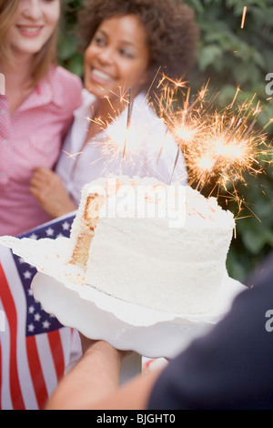 Mann, Kokos-Kuchen mit Wunderkerzen (4. Juli, USA) - Stockfoto
