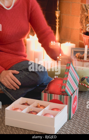 Frau Eröffnung Kisten mit Weihnachtsschmuck- Stockfoto