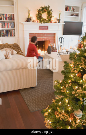 Frau Kamin im Wohnzimmer für Weihnachten dekoriert- Stockfoto