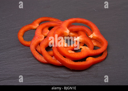 Geschnittene rote Paprika auf Hintergrund der dunklen Schiefer angeordnet. Stockfoto