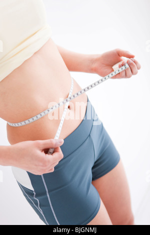 Frau, die ihre Taille messen Stockfoto