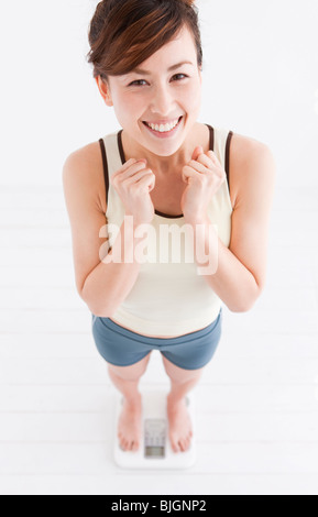 Frau, die sich auf Personenwaage wiegen Stockfoto