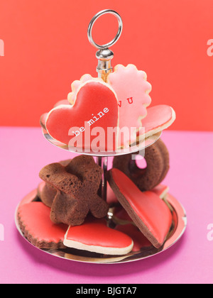 Herzförmige Kekse mit rosa & roten Glasur & Schokolade Kuchen- Stockfoto