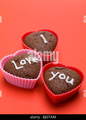 Herzförmige Schokoladen-Muffins für Liebhaber auf rotem Grund- Stockfoto