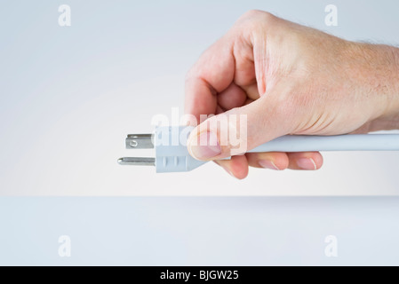 Hand mit Stecker Stockfoto