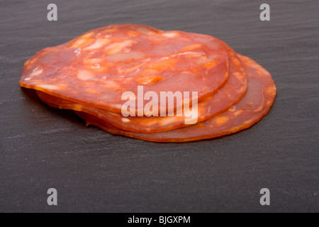 Chorizo-Scheiben aus niedrigen Winkel auf dunklem Schiefer. Stockfoto