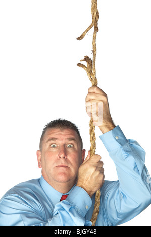 Ein Geschäftsmann hängt aus ein Ausfransen Seil. Stockfoto