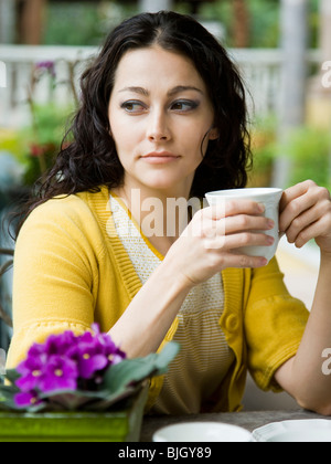 Frau hält einen Becher Stockfoto