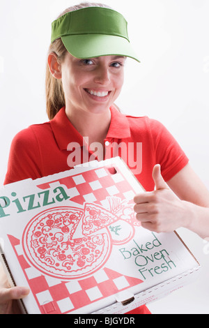Lächelnde Frau mit Pizza-Schachtel, Daumen geben, Zeichen- Stockfoto