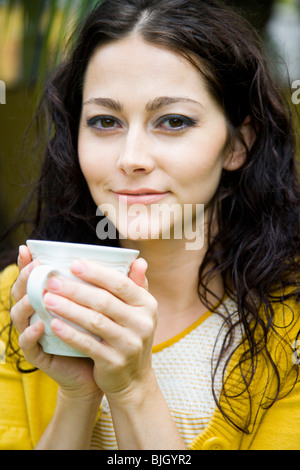 Frau hält einen Becher Stockfoto