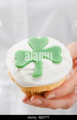 Hand halten Cupcake mit Marzipan-Kleeblatt- Stockfoto