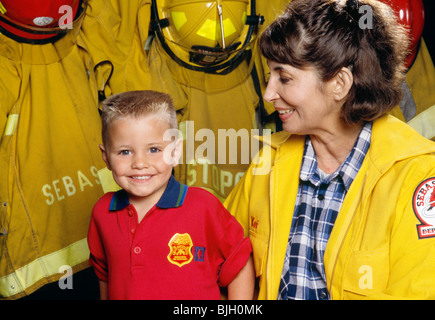 Weibliche Feuerwehrmann mit jungen Stockfoto