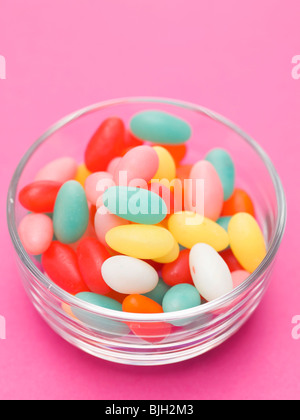 Farbige Zucker Eiern im Glas Schüssel, rosa Hintergrund- Stockfoto