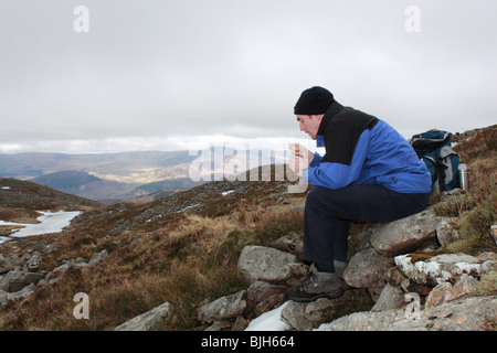 Walker nimmt sich eine Auszeit beim Aufstieg Cadair Idris über die steilen und instabilen Fox Weg, Snowdonia-Nationalpark, Gwynedd, Wales Stockfoto