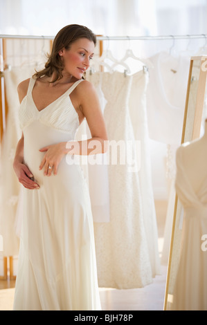 Frau versucht auf Hochzeitskleid Stockfoto