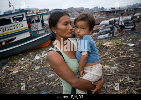 Eine Frau hält ihre Jungen an den Flussufern in Puerto Belen, Iquitos im peruanischen Amazonas-Becken. Stockfoto