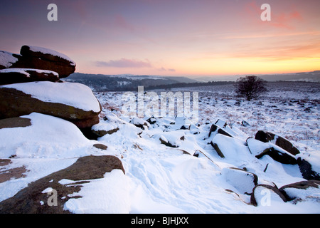 Sonnenuntergang von einem verschneiten Owler-Tor in der Peak District National Park Stockfoto