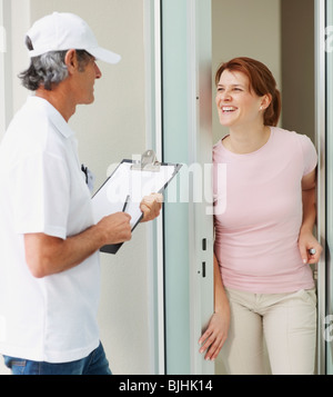 Frau im Gespräch mit dem Mann an der Tür Stockfoto