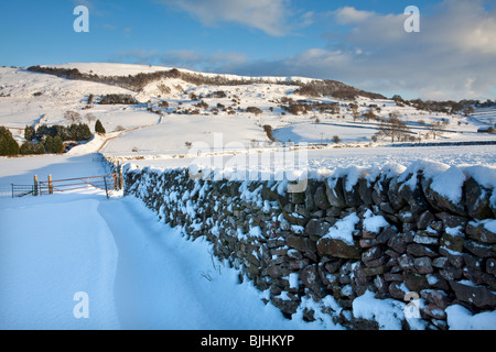 Verschneite Ackerland in der Nähe von Grindlow in der Peak District National Park an einem hellen sonnigen Wintertag Stockfoto