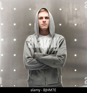 Mann in einem Kapuzenpullover mit seine Arme verschränkt Stockfoto