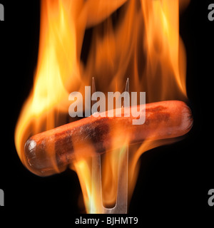 Hot Dog auf einer Gabel vollständig in Flammen verschlungen Stockfoto