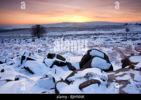 Sonnenuntergang von einem verschneiten Owler-Tor in der Peak District National Park Stockfoto