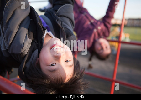 Jungen und Mädchen im Park schwingen auf barson Schule Spielplatz Spaß haben Stockfoto