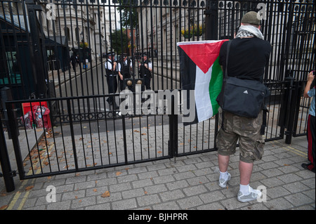 Mann hält palästinensische Flagge vor Downing Street Toren aus Protest als Israels Premierminister für Gespräche mit UK Premierminister Gordon Brown kommt Stockfoto