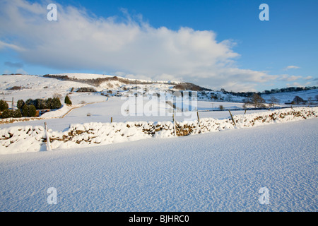 Verschneite Ackerland in der Nähe von Grindlow in der Peak District National Park an einem hellen sonnigen Wintertag Stockfoto