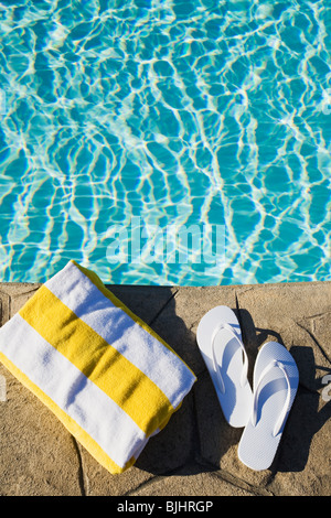 Flip Flops und Handtücher am Pool Stockfoto