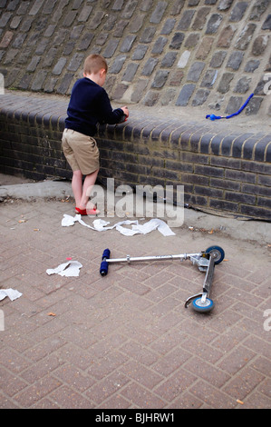 5 Jahre alter Junge durch Willen mit Spielzeug Roller auf Boden Stockfoto