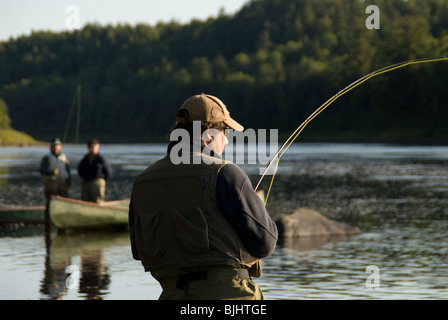 Troy Adams spielt seine ersten Atlantischen Lachs, Salmo salar, Miramichi River, New Brunswick, Kanada. Stockfoto