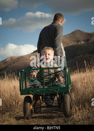 Vater zieht Sohn in Wagen Stockfoto