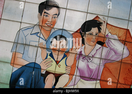 Ein Kachelofen Wandbild in einem Guangzhou Straße Befürworter "happy Families", und Chinas "Sheila" Politik für Familien, China. Stockfoto