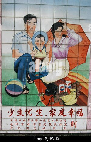 Ein Kachelofen Wandbild in einem Guangzhou Straße Befürworter "happy Families", und Chinas "Sheila" Politik für Familien, China. Stockfoto