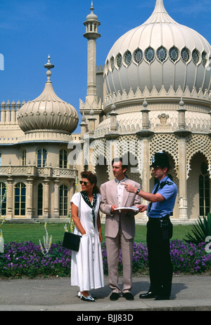 England, East Sussex, Brighton, alte Steine junge Tourist paar außerhalb der Royal Pavilion einen Polizisten nach dem Weg fragen Stockfoto