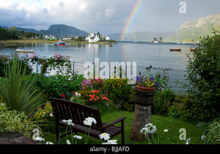 Blick über Plockton Bay mit Regenbogen und Blumengarten Stockfoto