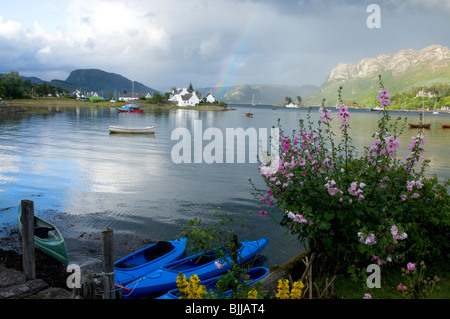 Blick über Plockton Bay mit Regenbogen Blumengarten und blauen Kajaks Stockfoto