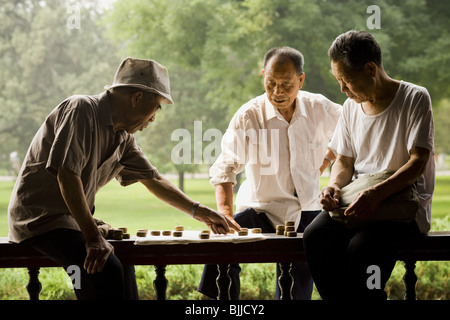 Drei Männer im freien lächelnd Brettspiel Stockfoto