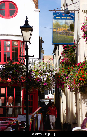 England, East Sussex, Brighton, The Lanes Old fashioned Straßenlaterne vor The Sussex Pub mit Blüten in hängenden Körben Stockfoto