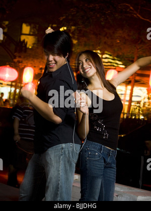 Paar, anhören von MP3-Player im freien tanzen und Lächeln Stockfoto