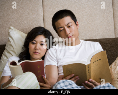 Paar im Bett kuscheln und lesen Stockfoto