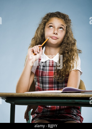 Mädchen sitzen am Schreibtisch mit der Arbeitsmappe Konzentration Stockfoto